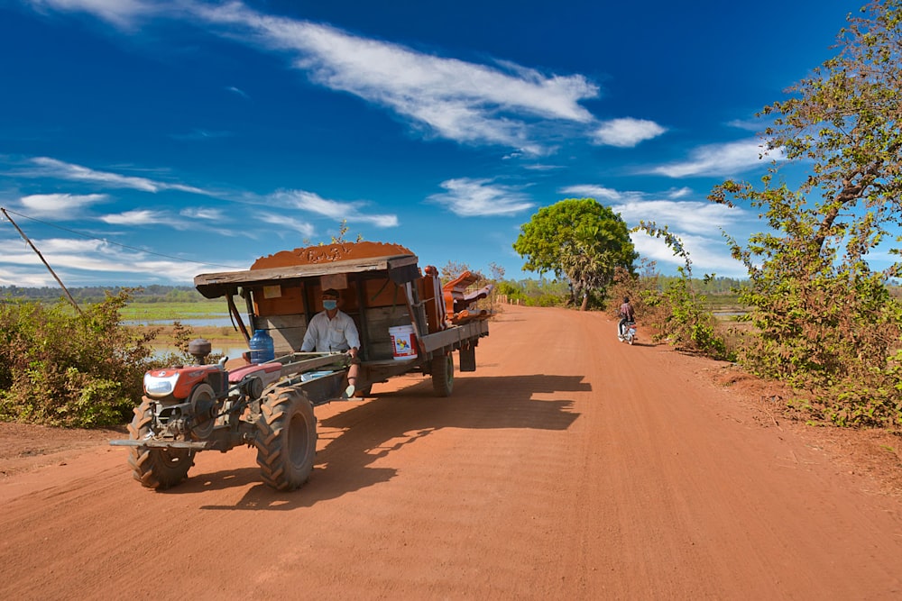 brown and black tractor on brown dirt road during daytime