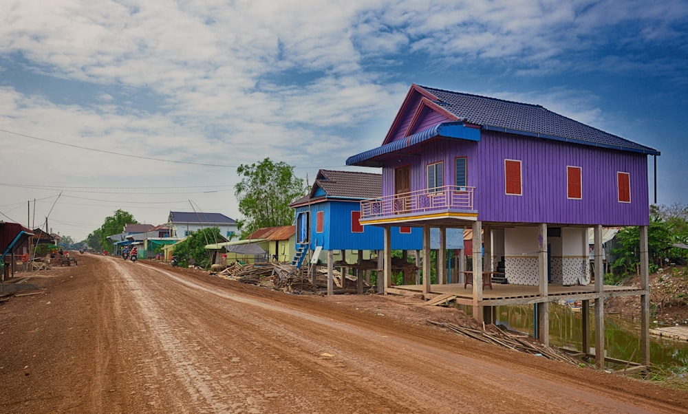 blue and pink wooden house near road under blue sky during daytime
