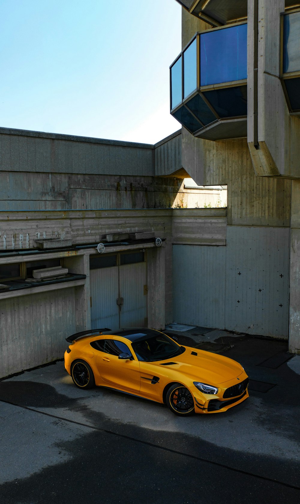 グレーのコンクリートの建物に駐車されたオレンジ色のフェラーリ458イタリア
