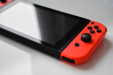 A close-up of colorful handheld game consoles laid out on a table.