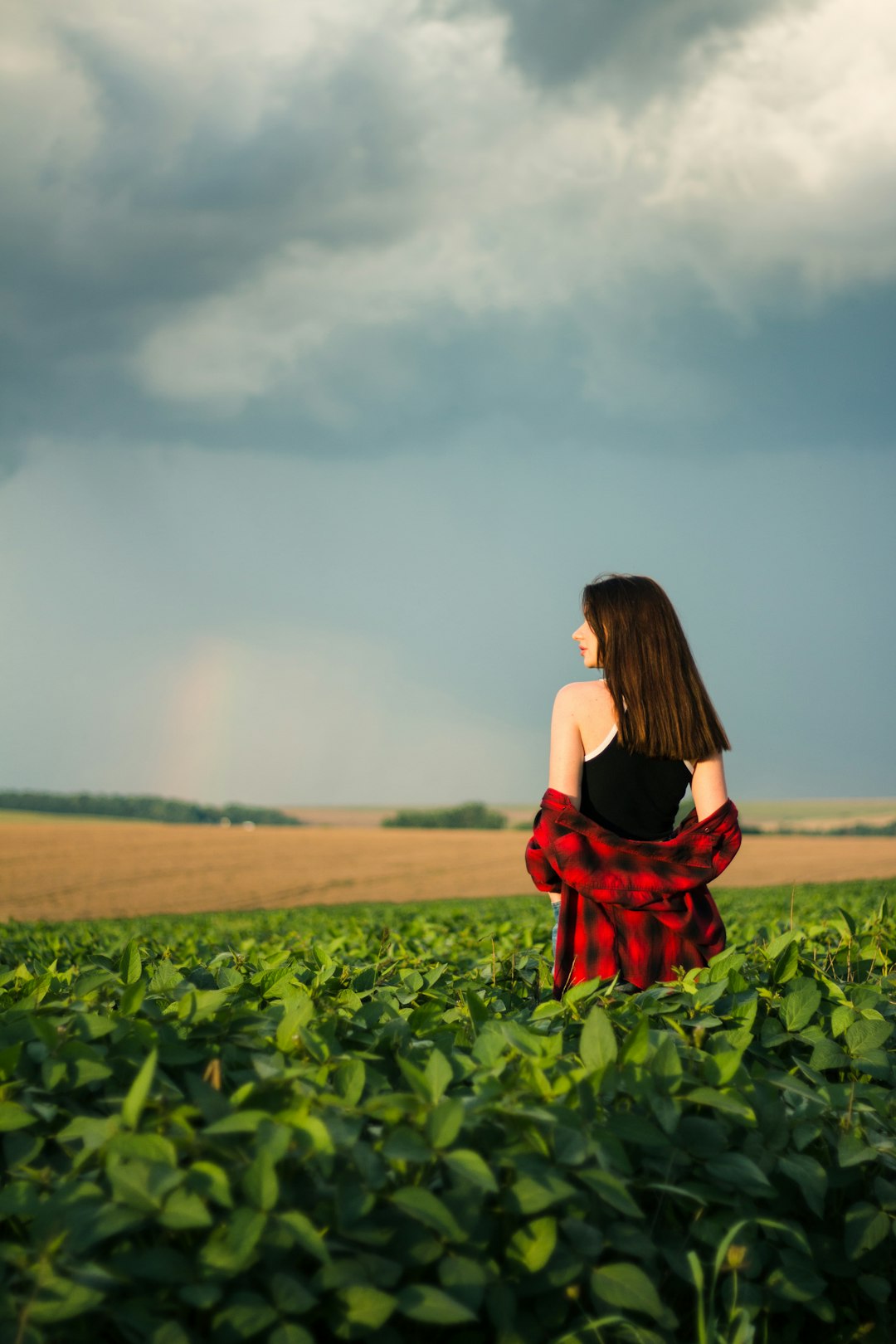 woman in red dress standing on green grass field during daytime