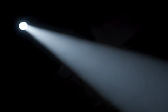 A sleek flashlight casting a bright beam in a dark room.