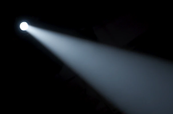 A sleek flashlight casting a bright beam in a dark room.