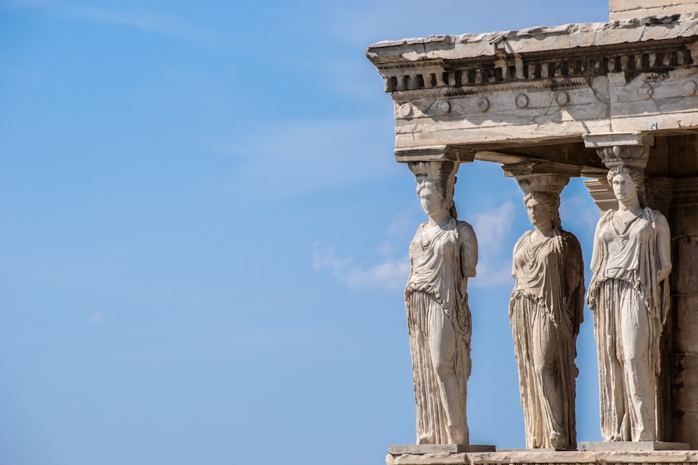 Statua di cemento marrone sotto il cielo blu durante il giorno