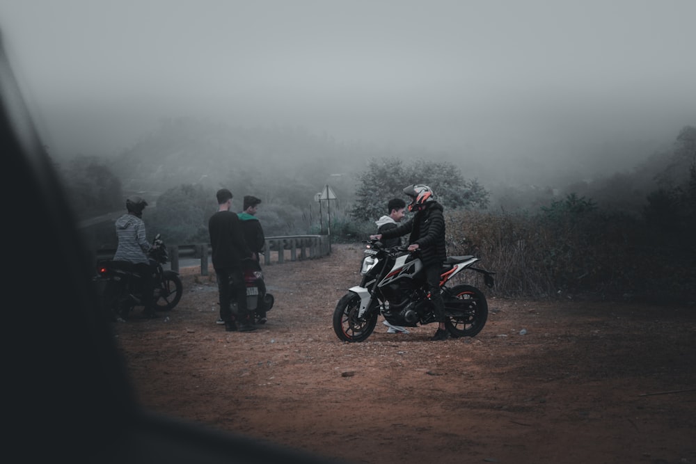 people riding motorcycle on road during foggy weather