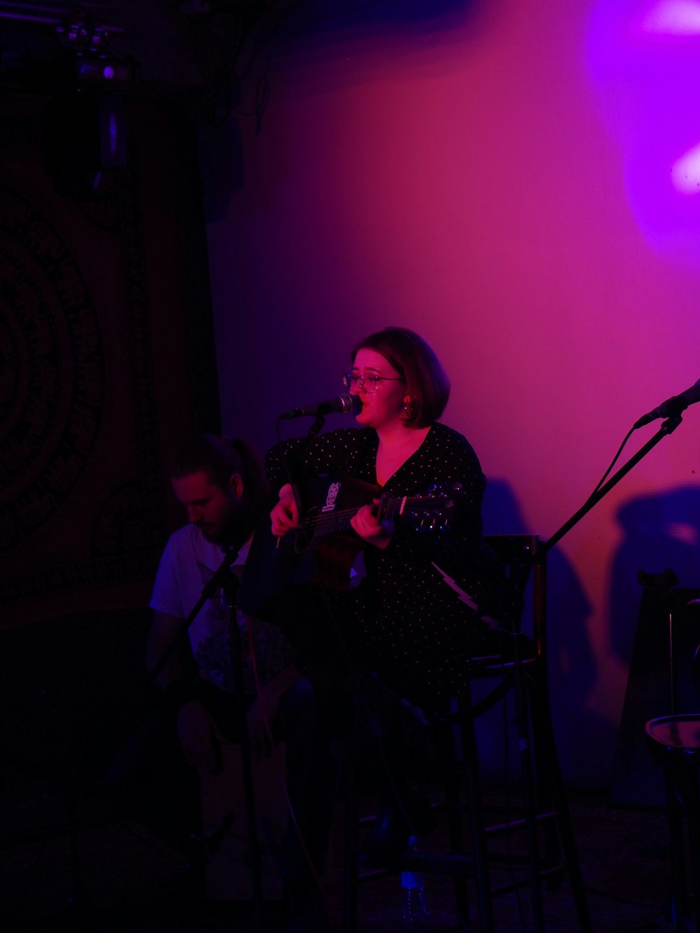 woman in black and white dress singing on stage