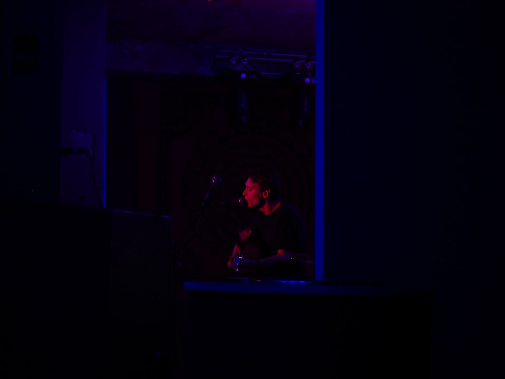 man in black shirt standing on stage