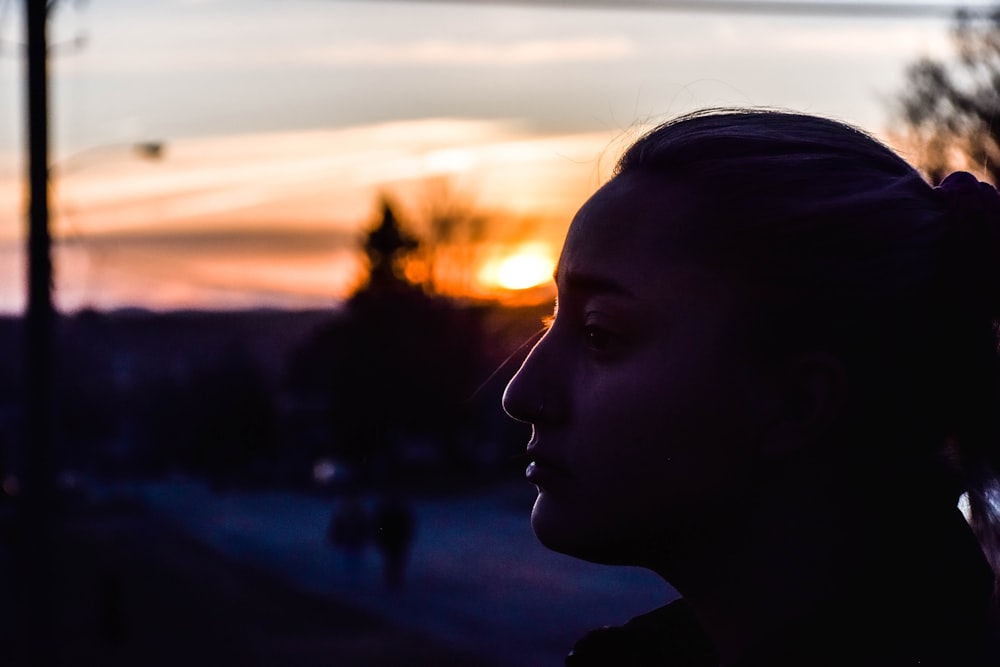 woman in black shirt looking at the sunset