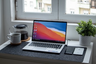 A clean, modern workspace with a laptop and a cup of coffee.