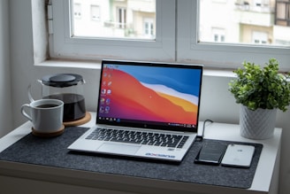 A clean workspace with a laptop and a cup of coffee on the desk