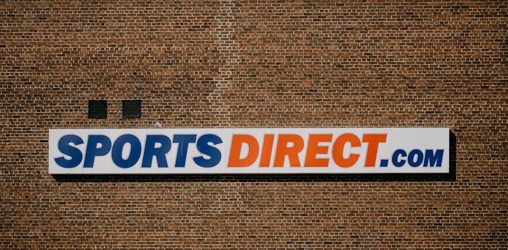 a sports direct sign on a brick wall