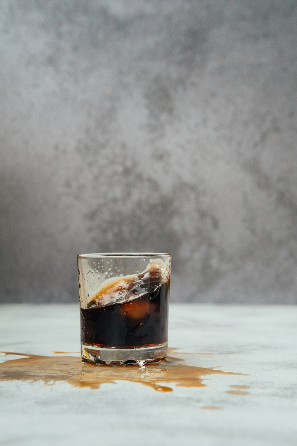 clear shot glass with brown liquid