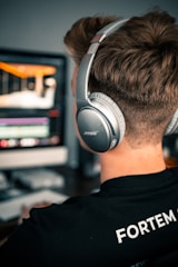 man in black and white crew neck shirt wearing black and gray headphones