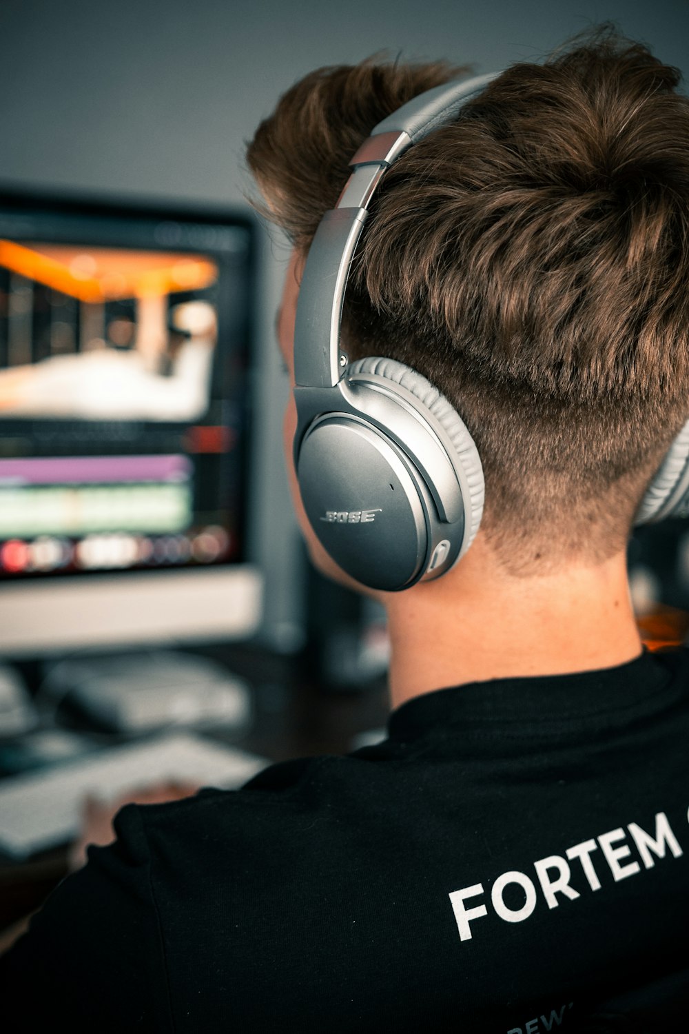 man in black and white crew neck shirt wearing black and gray headphones