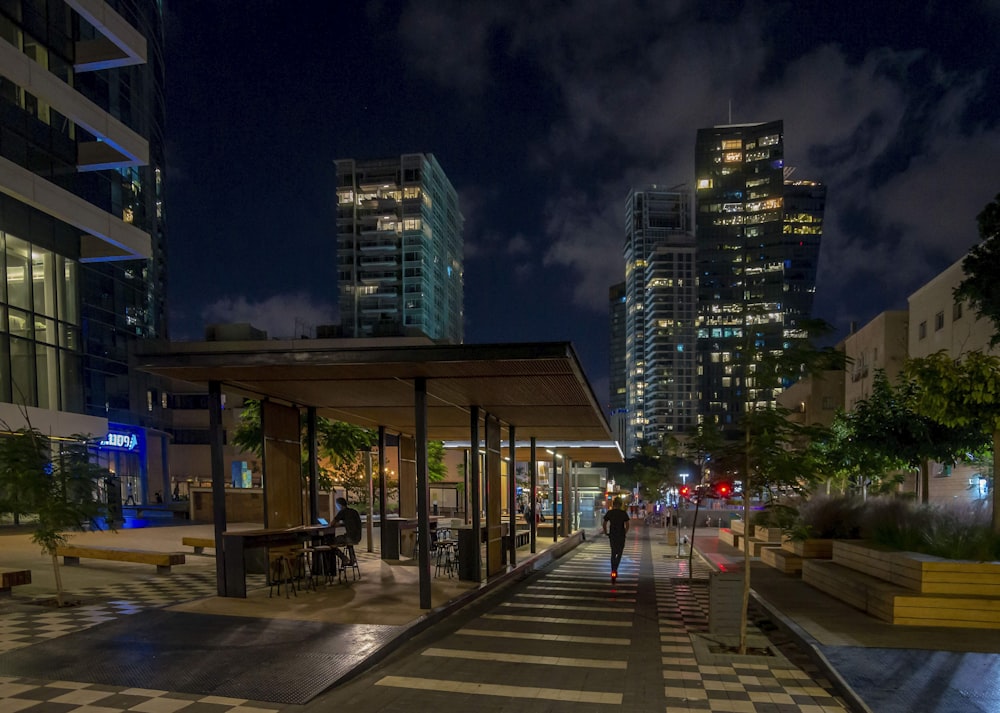 people walking on sidewalk near building during night time