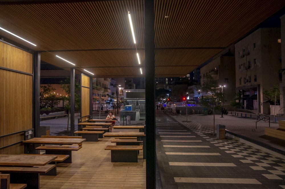 brown wooden bench on sidewalk during night time
