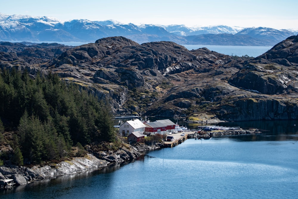 houses near body of water and mountain during daytime