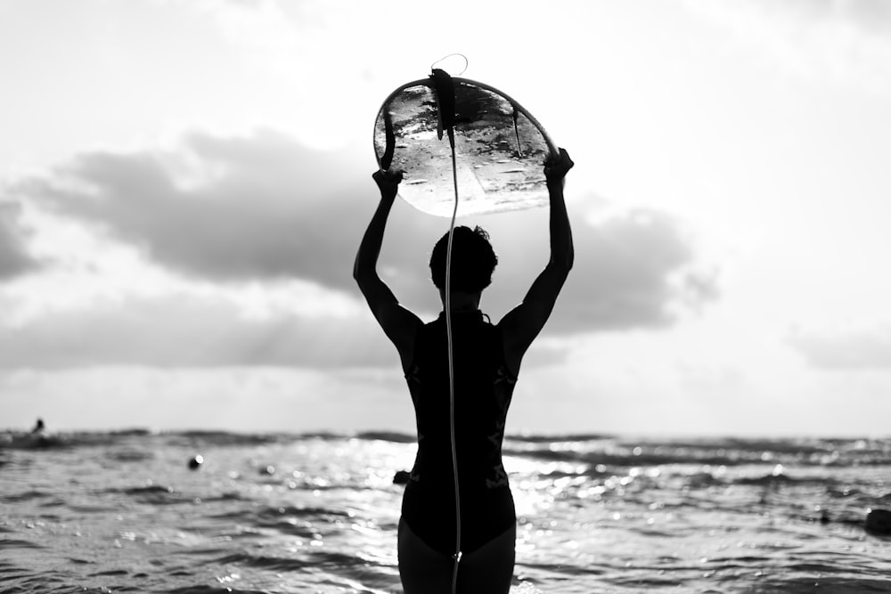 mulher na regata preta e leggings pretas segurando a bola de vidro transparente na fotografia em escala de cinza