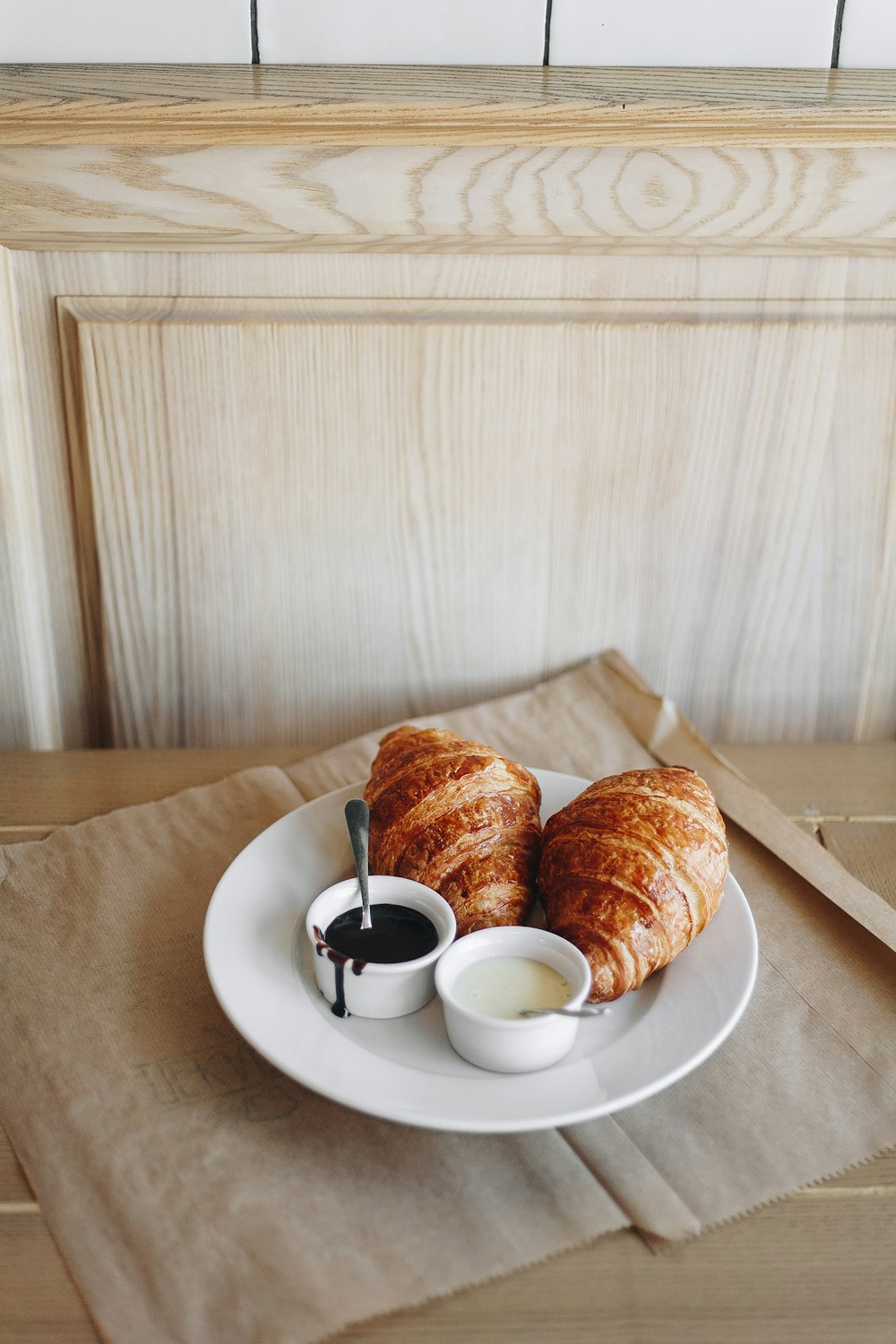 bread on white ceramic plate beside white ceramic teacup on saucer