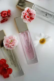 Elegant perfume bottles arranged on a wooden table with fresh flowers