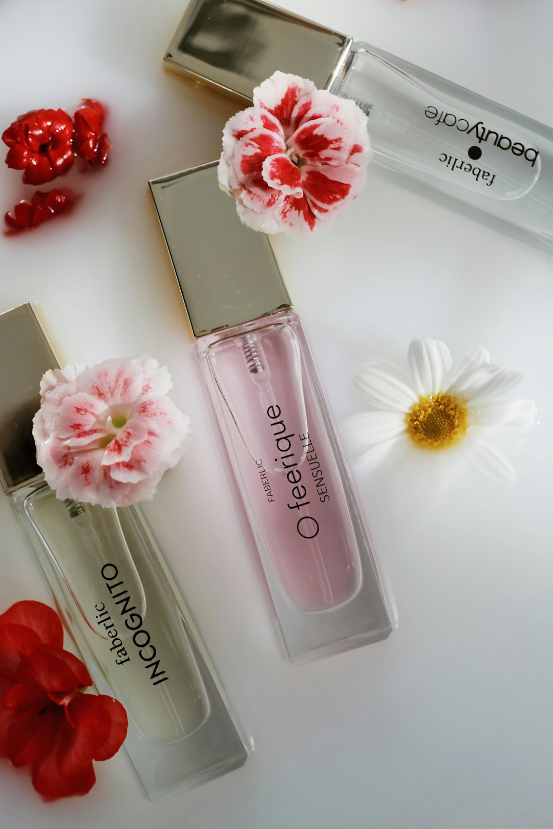 pink flower beside pink perfume bottle