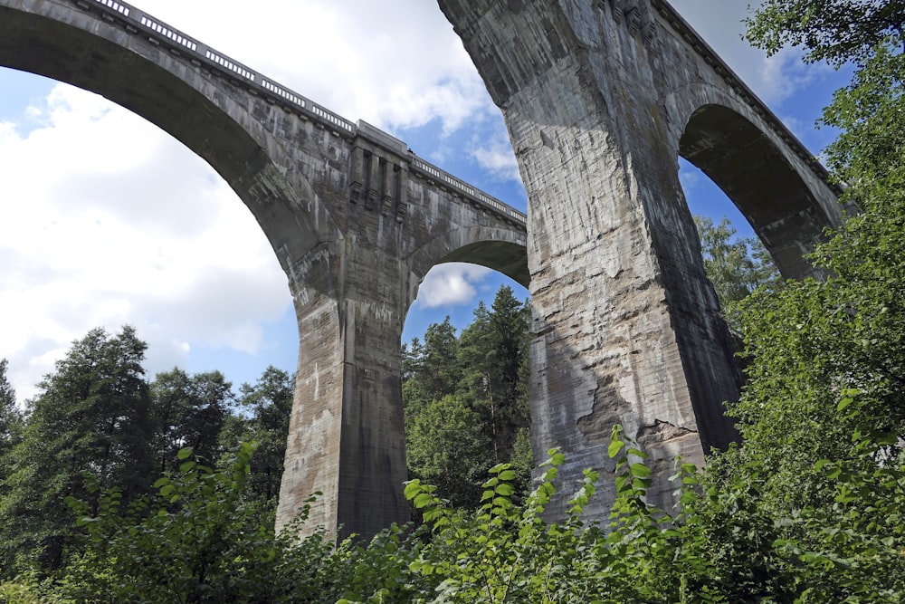 brown concrete bridge over green grass field during daytime