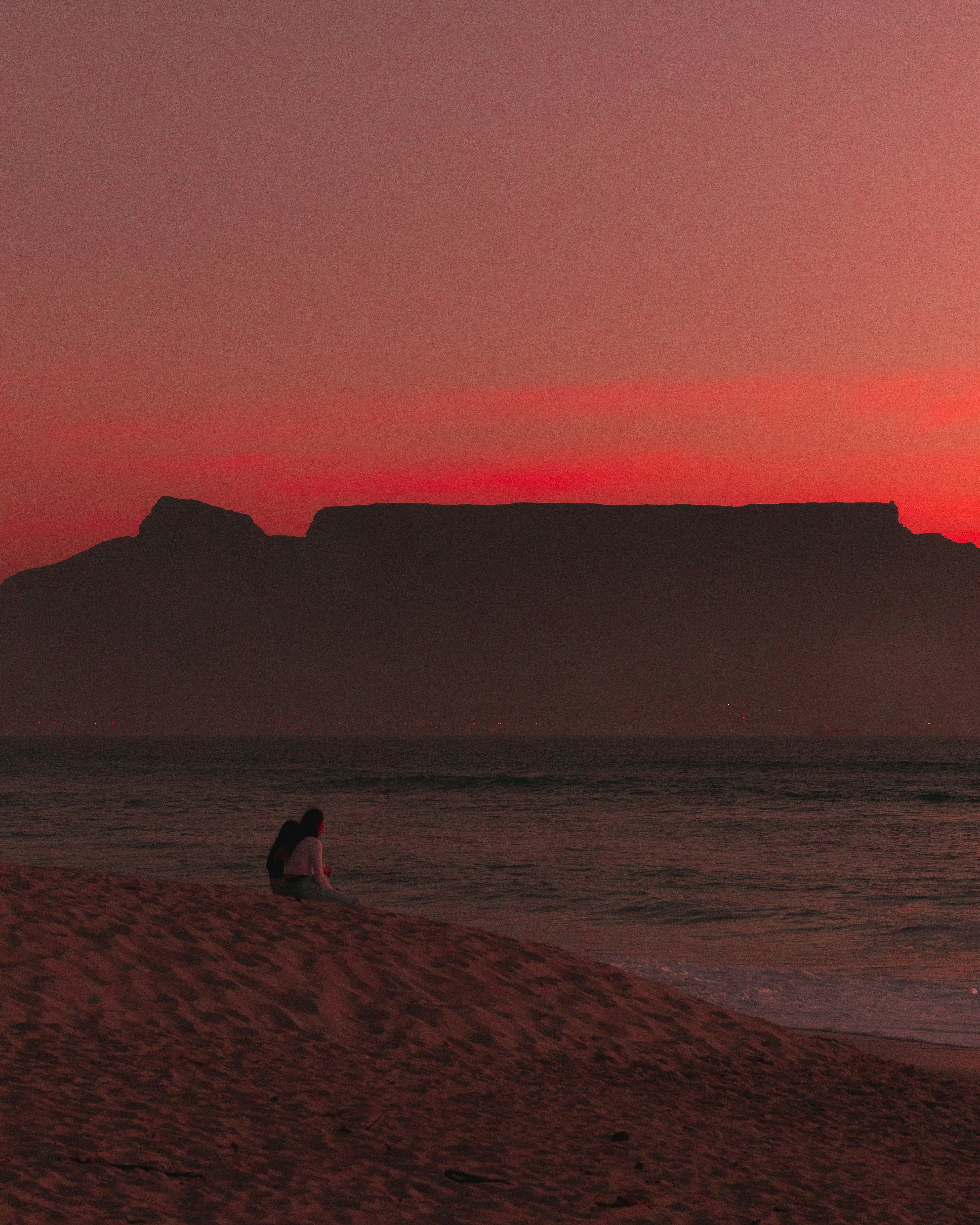 silhouette di 2 persone che camminano sulla spiaggia durante il tramonto