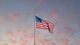us a flag on pole under cloudy sky