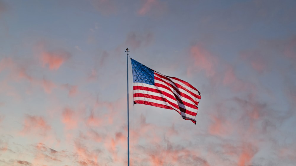 us a flag on pole under cloudy sky