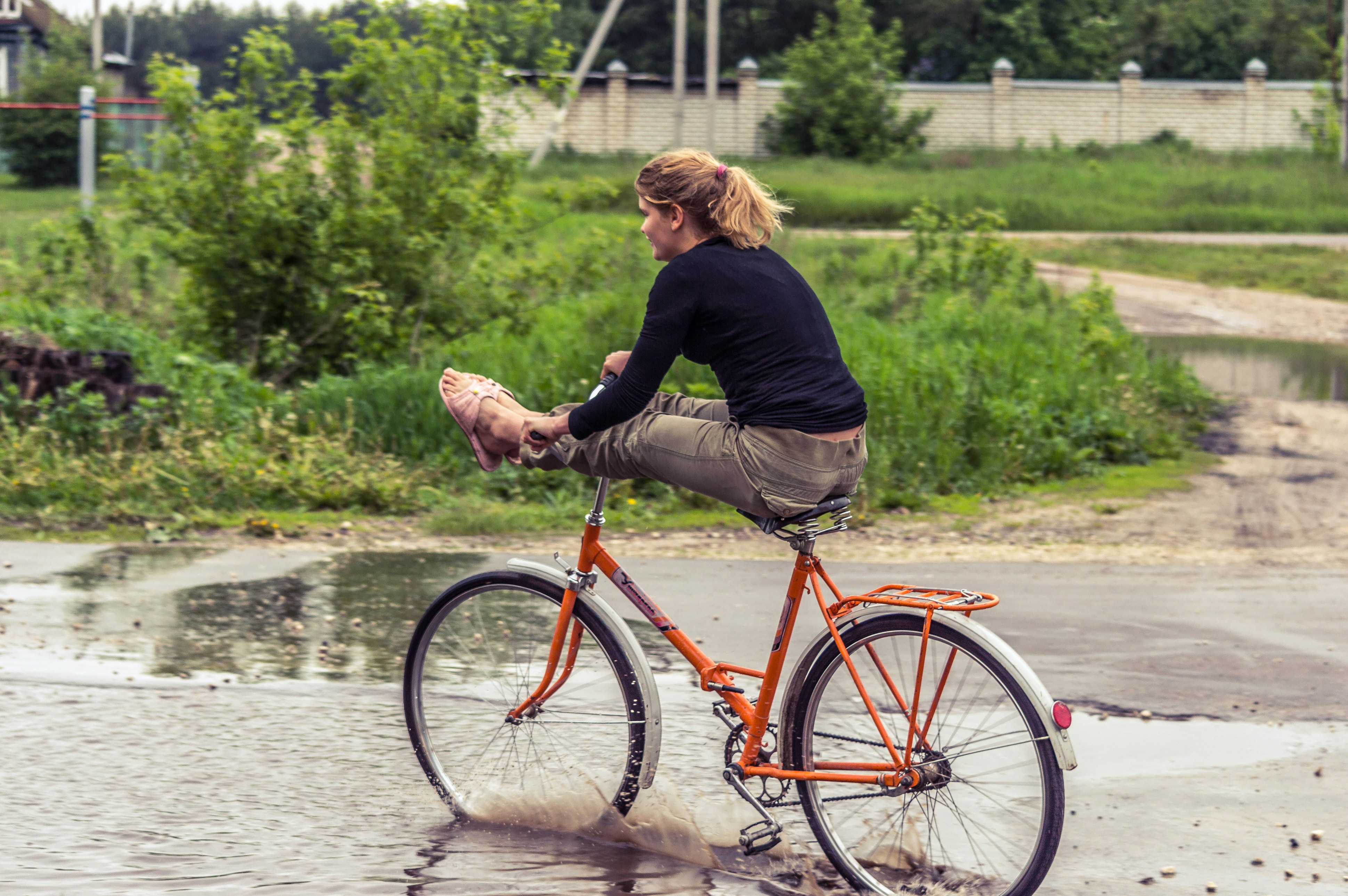 woman in black long sleeve shirt riding red bicycle on river during daytime
