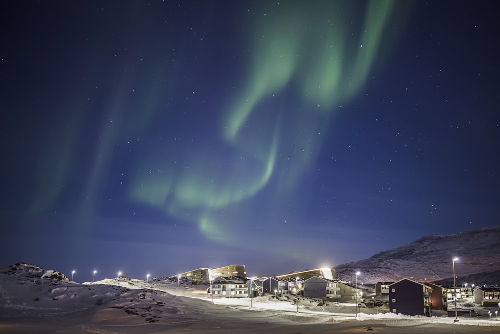 casas brancas e marrons sob o céu verde durante a noite