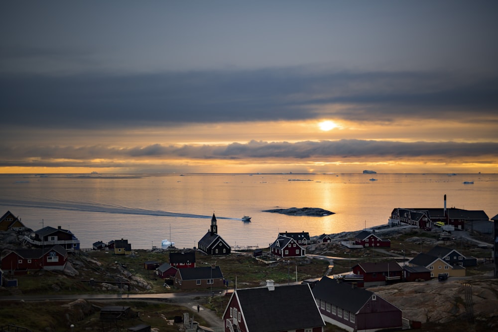 houses near body of water during sunset