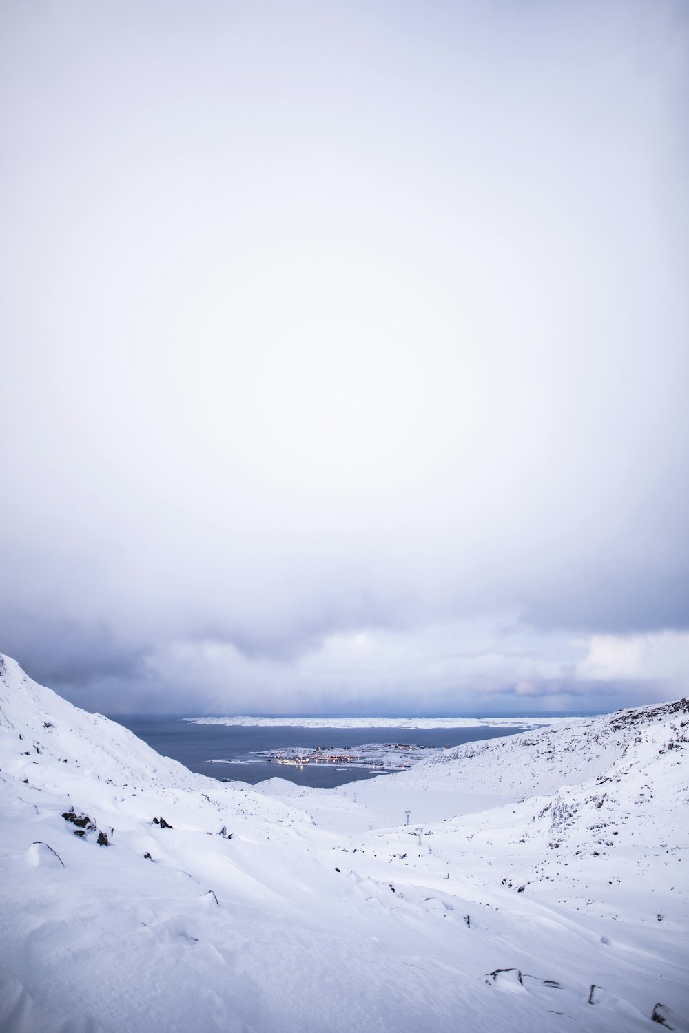 snow covered mountain under white clouds during daytime