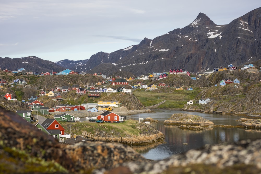 houses near lake and mountain during daytime