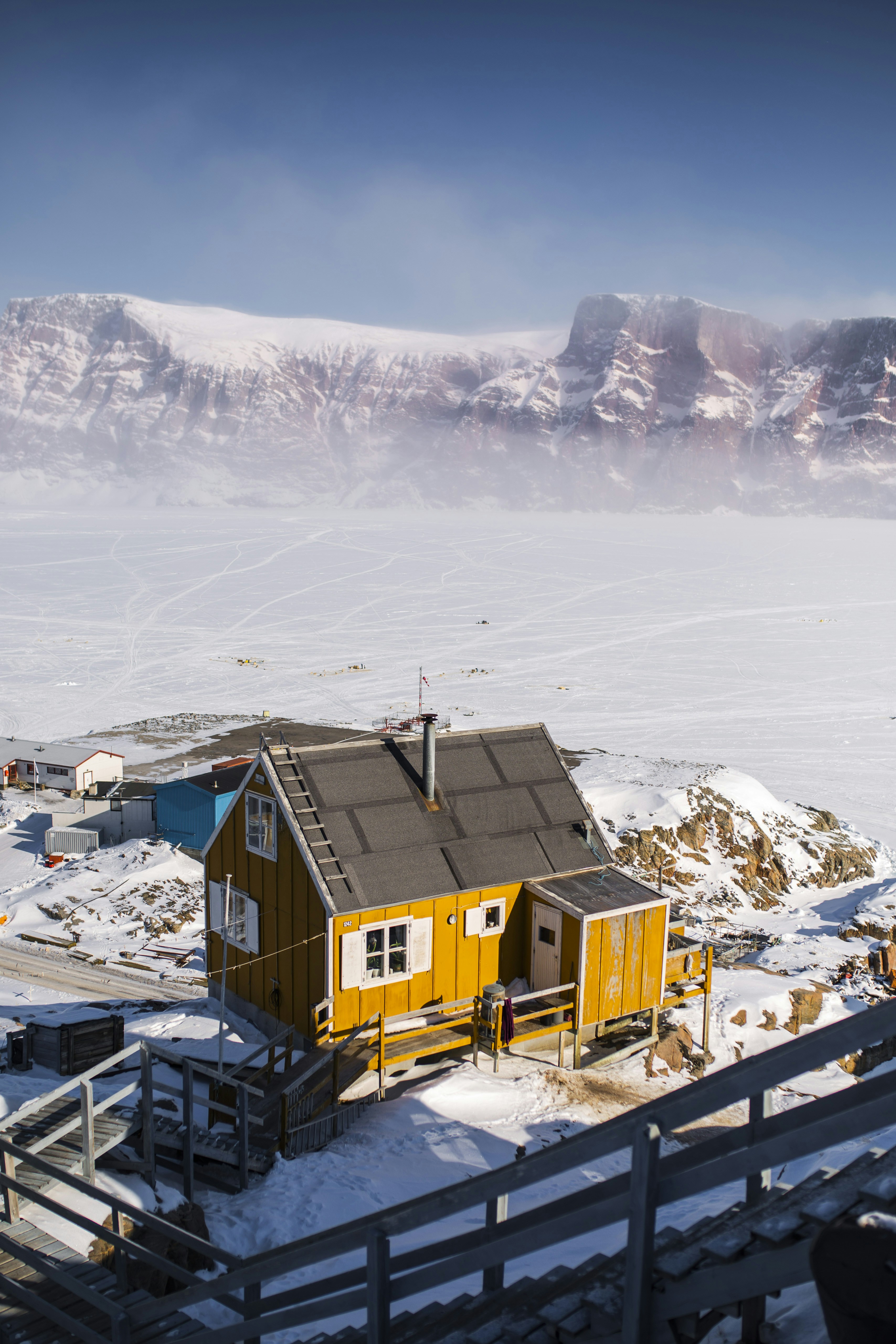 Casa de madera marrón en suelo cubierto de nieve durante el día