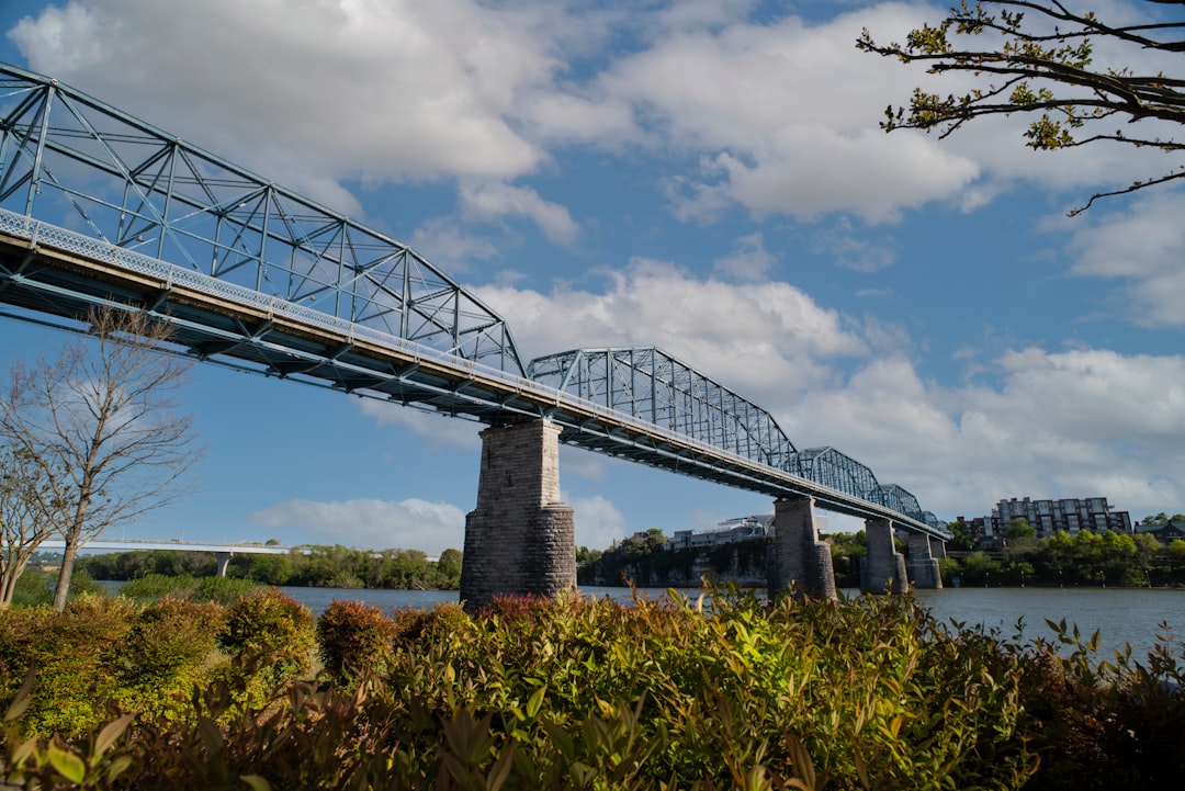 gray metal bridge under cloudy sky during daytime