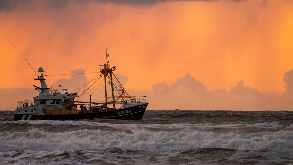 black and brown boat on sea during sunset