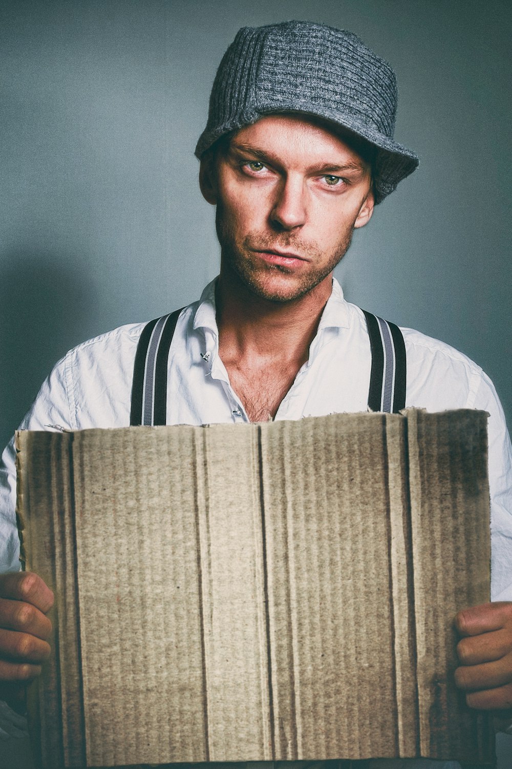 man in black and white shirt holding brown book