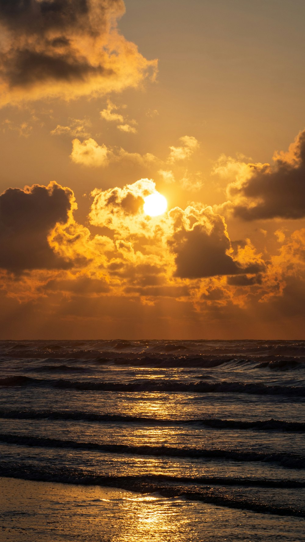 Meereswellen, die bei Sonnenuntergang an Land stürzen