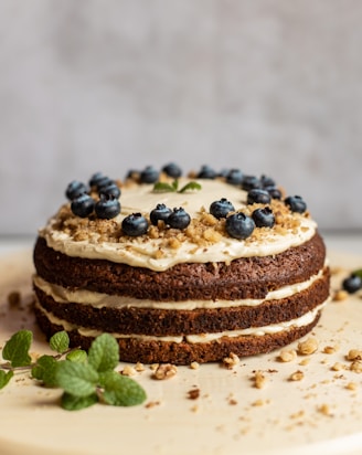 brown and black pastry with blue berries on white ceramic plate