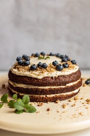 brown and black pastry with blue berries on white ceramic plate