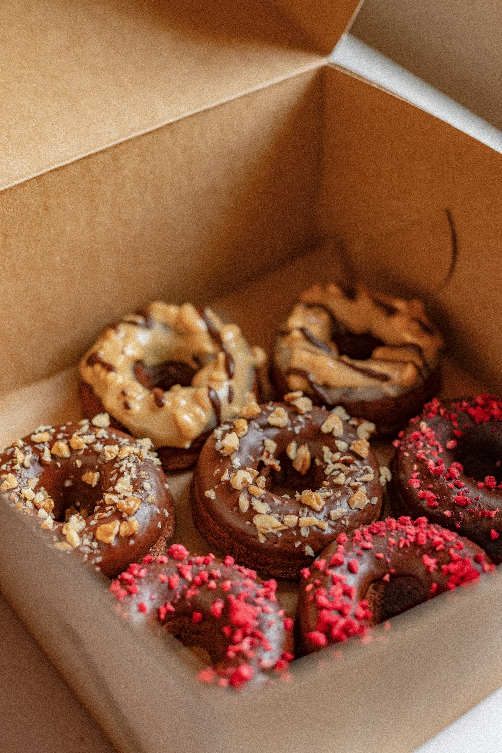 brown and pink donuts in box