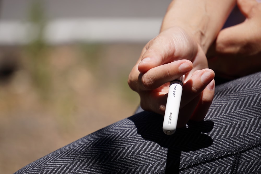 person holding white plastic tube