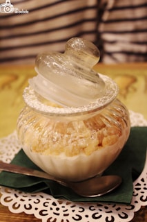Close-up of a creamy tiramisu in a rustic glass jar with a dusting of cocoa powder on top