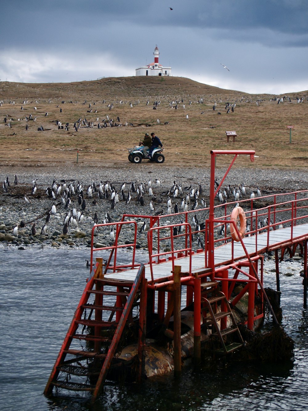 Personnes sur le pont métallique rouge au-dessus de la mer pendant la journée