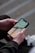 A person using a smartphone with a construction app interface visible on the screen.