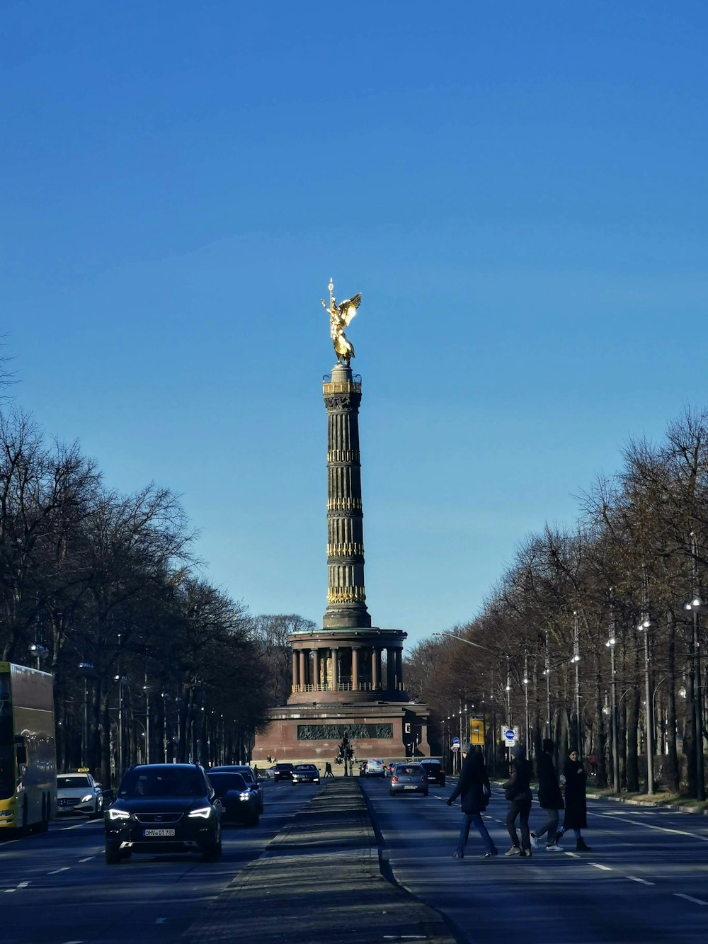 people walking on street near black and white tower during daytime