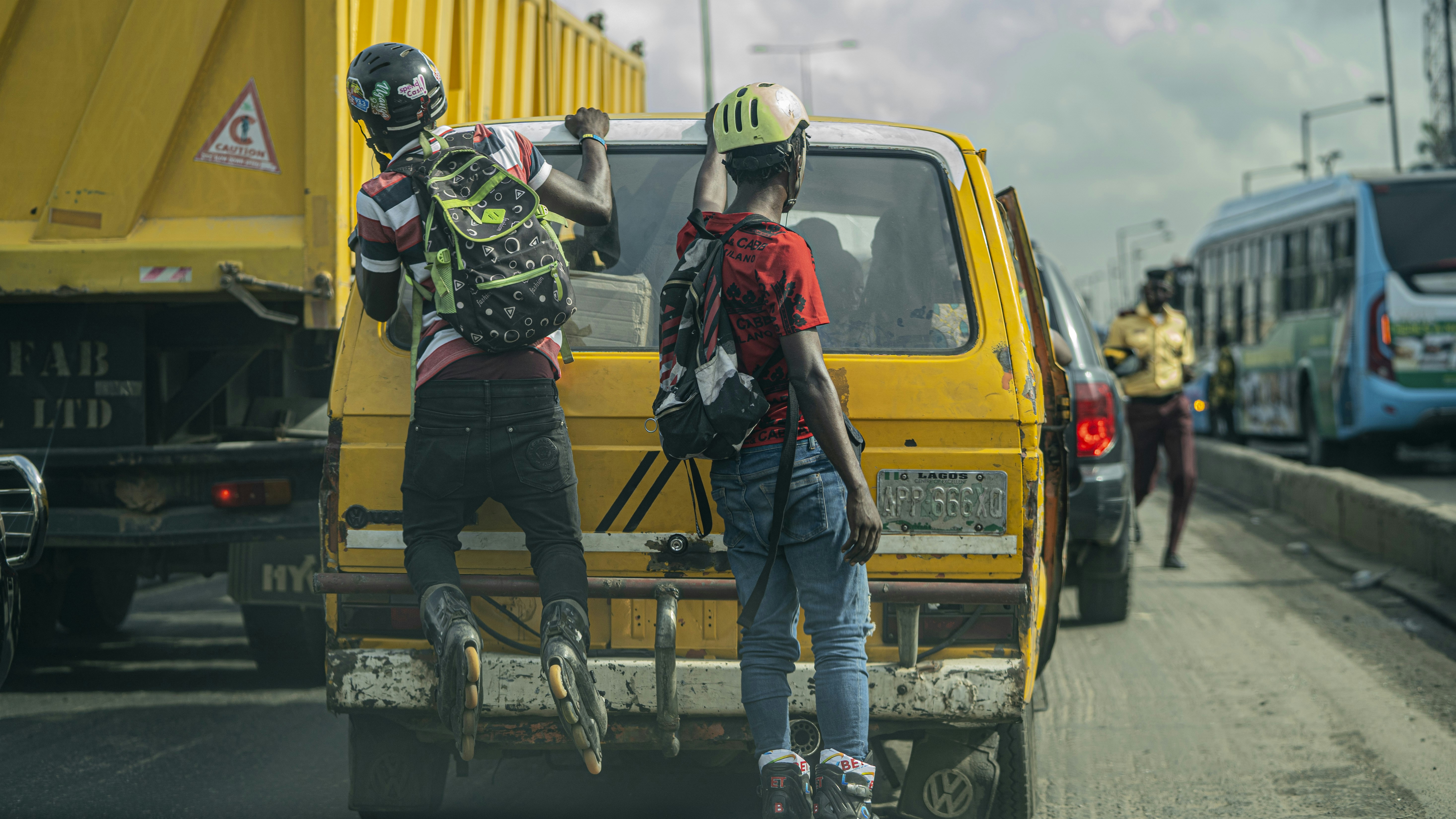 A dispatch rider wearing a helmet weaving through traffic in Lagos, Nigeria.