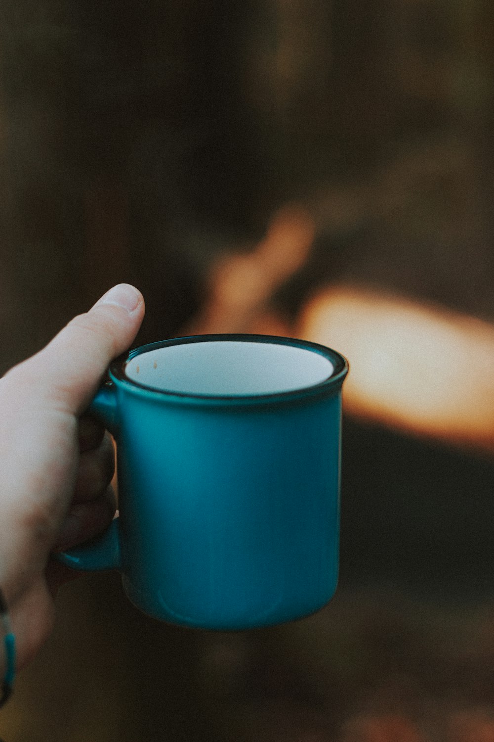 person holding blue ceramic mug