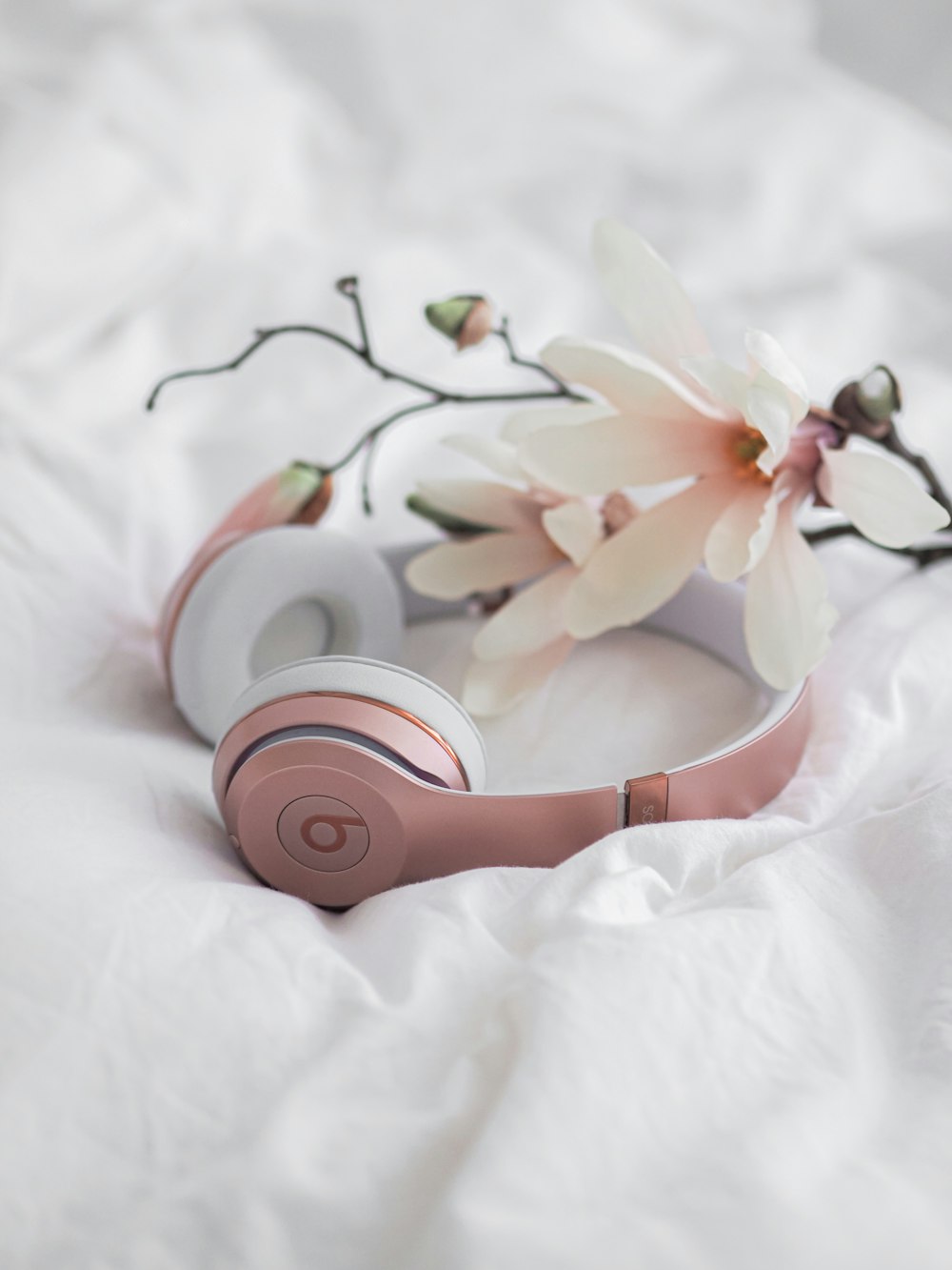 pink beats by dr dre headphones on white textile